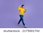 Small photo of Full body photo of delighted positive man raise fist celebrate like subscribe walk isolated on violet color background