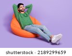 Small photo of Full length photo of young latin man laying beanbag daydreaming chilling dressed stylish green garment isolated on purple color background