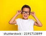 Small photo of Photo of satisfied cute boy trendy outfit arm touch glasses look empty space rejoice sale eye accessory isolated on yellow color background
