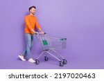 Full size photo of good mood shopaholic male go shopping in city center mall isolated on purple color background