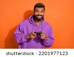 Portrait of satisfied glad man hold controller use playstation toothy smile isolated on orange color background