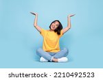 Full body size photo of young japanese pretty girl bob brunette hair interested look up hold palms object advert empty space isolated on blue color background