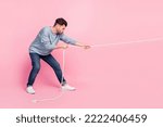 Profile side full length photo of determined guy ready pull string tug war conflict isolated on pastel color background