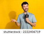Small photo of Photo of positive talented man announcer speak mic tell breaking true news empty space isolated on yellow color background