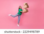 Small photo of Full size photo of impressed gorgeous clumsy girl dressed green t-shirt jeans falling with boxes isolated on pink color background