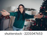 Photo of adorable excited girl wear xmas green pullover open arms ready hug you indoors home room