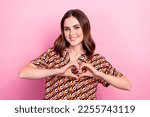 Photo portrait of attractive young woman showing heart symbol fingers like dressed stylish print outfit isolated on pink color background