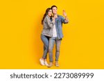 Full length photo of attractive sweet couple wear jeans recording video vlog modern device isolated yellow color background