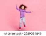 Small photo of Full length photo of cheerful funky small kid wear violet sweater jumping high isolated pink color background