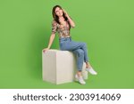 Full body size photo cadre of dreamy young woman call her boyfriend look mockup sit podium viber messenger isolated on green background