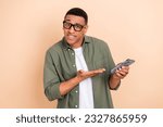 Portrait of clever man glasses stylish shirt palm directing at smartphone facebook twitter whatsapp isolated on beige color background