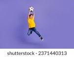 Full size photo of cute young schoolboy jumping catch football ball wear yellow clothes isolated on purple color background