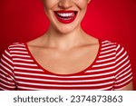 Small photo of Cropped close portrait of young lovely lady showing perfect smile licking teeth wearing striped t shirt isolated on red color background