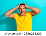Small photo of Portrait of young funny man wear yellow stylish t-shirt hands head surprised reaction biggest sale ever isolated on cyan color background