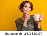 Small photo of Photo of pretty young girl hold coffee mug look minded empty space dressed stylish knitted khaki outfit isolated on yellow color background