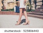 Close up of slim legs of woman wearing high heel shoes.