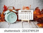 September 2023 monthly calendar maple leaf decoration on wooden background