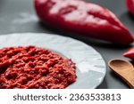 Small photo of Red pepper ajvar, a delicious dish for winter...ajvar od crvene paprike...caviar of baked red bell pepper on grey...vegetable sauce...