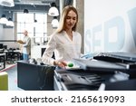 Young employee using modern printer in office