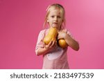Little Girl Holding Pumpkin In...