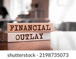 Small photo of Financial Outlay text concept written on wooden blocks lying on a table