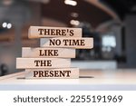 Wooden blocks with words 'There's no Time Like the Present'.