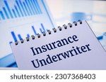 Small photo of Notepads with the inscription Insurance Underwriter. Business concept