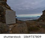Historic plaque on pile of stones on top of Keiservarden mountain near Digermulen, Hinnøya island, Lofoten, Norway. Text (in focus): German Emperor Wilhelm II visited this place in 1903.