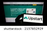 Small photo of Stuttgart, Germany - 05-15-2022: Person holding smartphone with logo of US fintech company Upstart Network Inc. on screen in front of website. Focus on phone display. Unmodified photo.