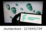 Small photo of Stuttgart, Germany - 06-25-2022: Person holding cellphone with logo of Croatian conglomerate Fortenova Group on screen in front of business webpage. Focus on phone display. Unmodified photo.