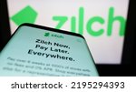 Small photo of Stuttgart, Germany - 03-30-2022: Smartphone with website of fintech Zilch Technology Limited (PayZilch) on screen in front of business logo. Focus on top-left of phone display. Unmodified photo.