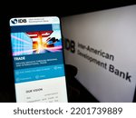 Small photo of Stuttgart, Germany - 09-07-2022: Person holding cellphone with webpage of Inter-American Development Bank (IADB) on screen in front of logo. Focus on center of phone display. Unmodified photo.