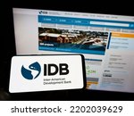 Small photo of Stuttgart, Germany - 09-07-2022: Person holding cellphone with logo of Inter-American Development Bank (IADB) on screen in front of business webpage. Focus on phone display. Unmodified photo.