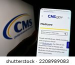 Small photo of Stuttgart, Germany - 09-22-2022: Person holding cellphone with webpage of Centers for Medicare and Medicaid Services (CMS) on screen with logo. Focus on center of phone display. Unmodified photo.