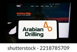 Small photo of Stuttgart, Germany - 10-18-2022: Person holding mobile phone with logo of Saudi business Arabian Drilling Company (ADC) on screen in front of web page. Focus on phone display. Unmodified photo.