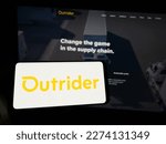 Small photo of Stuttgart, Germany - 03-07-2023: Person holding smartphone with logo of US company Outrider Technologies Inc. on screen in front of website. Focus on phone display. Unmodified photo.