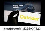 Small photo of Stuttgart, Germany - 03-07-2023: Person holding cellphone with logo of US company Outrider Technologies Inc. on screen in front of business webpage. Focus on phone display. Unmodified photo.
