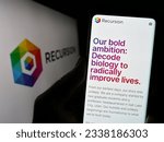 Small photo of Stuttgart, Germany - 07-19-2023: Person holding cellphone with website of US company Recursion Pharmaceuticals Inc. on screen in front of logo. Focus on center of phone display. Unmodified photo.