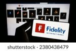 Small photo of Stuttgart, Germany - 07-04-2023: Person holding mobile phone with logo of financial company Fidelity International Ltd. on screen in front of web page. Focus on phone display. Unmodified photo.