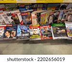Small photo of Paris, France - Apr 17, 2022: POV male hand holding inside press kiosk the latest issue of L'Express, L'Obs, Valeurs, Le Point, Gaston magazines newspapers featuring Emmanuel Macron candidate to