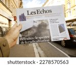 Small photo of Paris, France - Mar 20, 2023: The specter of radicalization - retiring - title on the Les Echos newspaper being read by man's in hand