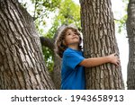 Young Boy Hugging A Tree Branch....