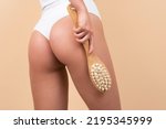 Anti cellulite massage with brush. Woman legs with clean skin. Female buttocks ass without cellulite. Skin treatment. Anti-cellulite body massage for leg and butt. Spa and wellness, body care.