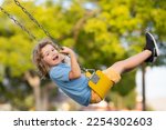 Outdoor playground. Funny kid on swing. Little boy swinging on playground. Happy cute excited child on swing. Cute child swinging on a swing. Crazy playful child swinging very high.