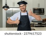 Small photo of Happy chef cook with thumb up. Portrait of chef man in a chef cap in the kitchen. Man wearing apron and chefs uniform and chefs hat. Character kitchener, chef for advertising.