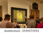 Small photo of Vienna, Austria - 25.08.2022: Tourists looking and making photos near the original Gustav Klimt painting The Kiss in Austrian Gallery Belvedere