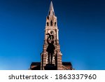 Small photo of powerfull image of city Roeselare in flanders Belgium. Silhoutte of statue from a boy releasing a bird on a market combined with a church tower and a clear blue sky. De coninckplein, merlina square