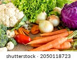 Various vegetables, cauliflower, broccoli, tomato, onion, carrot, lettuce and cabbage.
