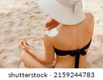 Small photo of Woman applying sunscreen creme on tanned shoulder. Skin care. Body Sun protection sun cream. Bikini hat woman applying moisturizing sunscreen lotion on back.