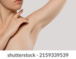 Small photo of Skin care. Armpit epilation, laser hair removal. Young woman holding her arms up and showing clean underarms.